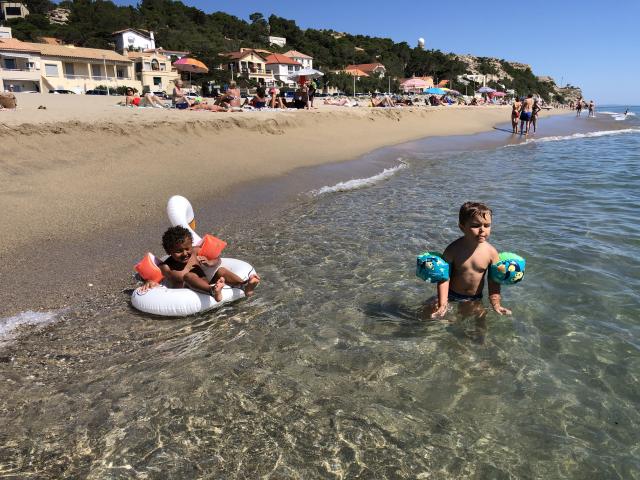 Photo d'enfants avec brassards et bouée sur la plage de Leucate Plage