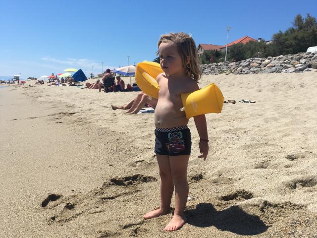 Photo d'un enfant avec ses brassards sur la plage de Leucate Plage