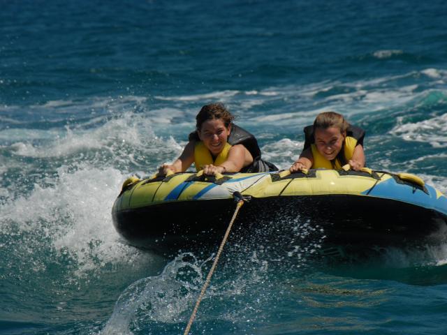 Photo de 2 personnes sur une bouée tractée