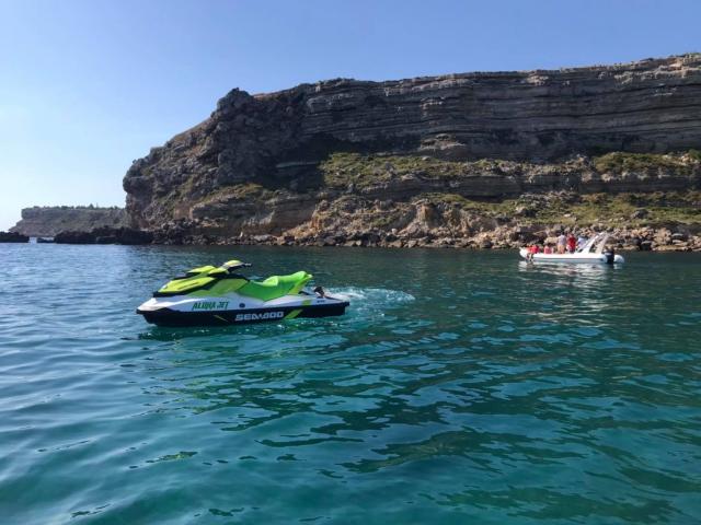 Photo de jet ski au large de Leucate, en fond la falaise et des personnes qui se baignent