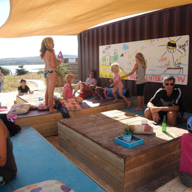 photo de la terrasse du Wesh Center Crew, plusieurs familles et enfants en train de manger sur des tables basses